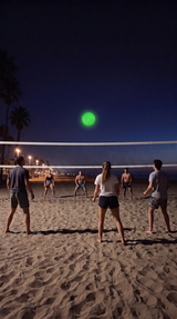 Friends playing beach volleyball at night with a glowing GLOVA ball